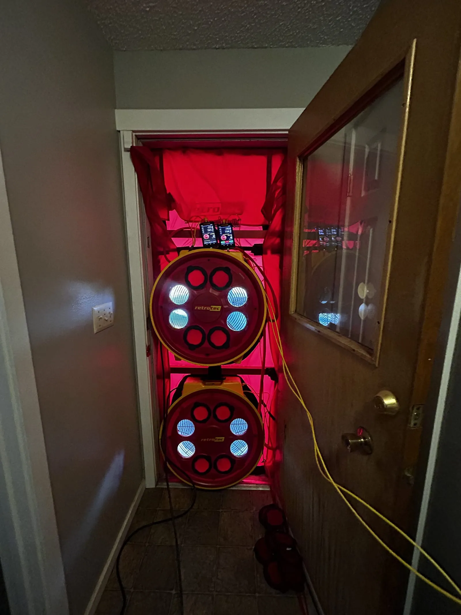 Two Retrotec blower door fans set up in an exterior doorway during an air leakage test